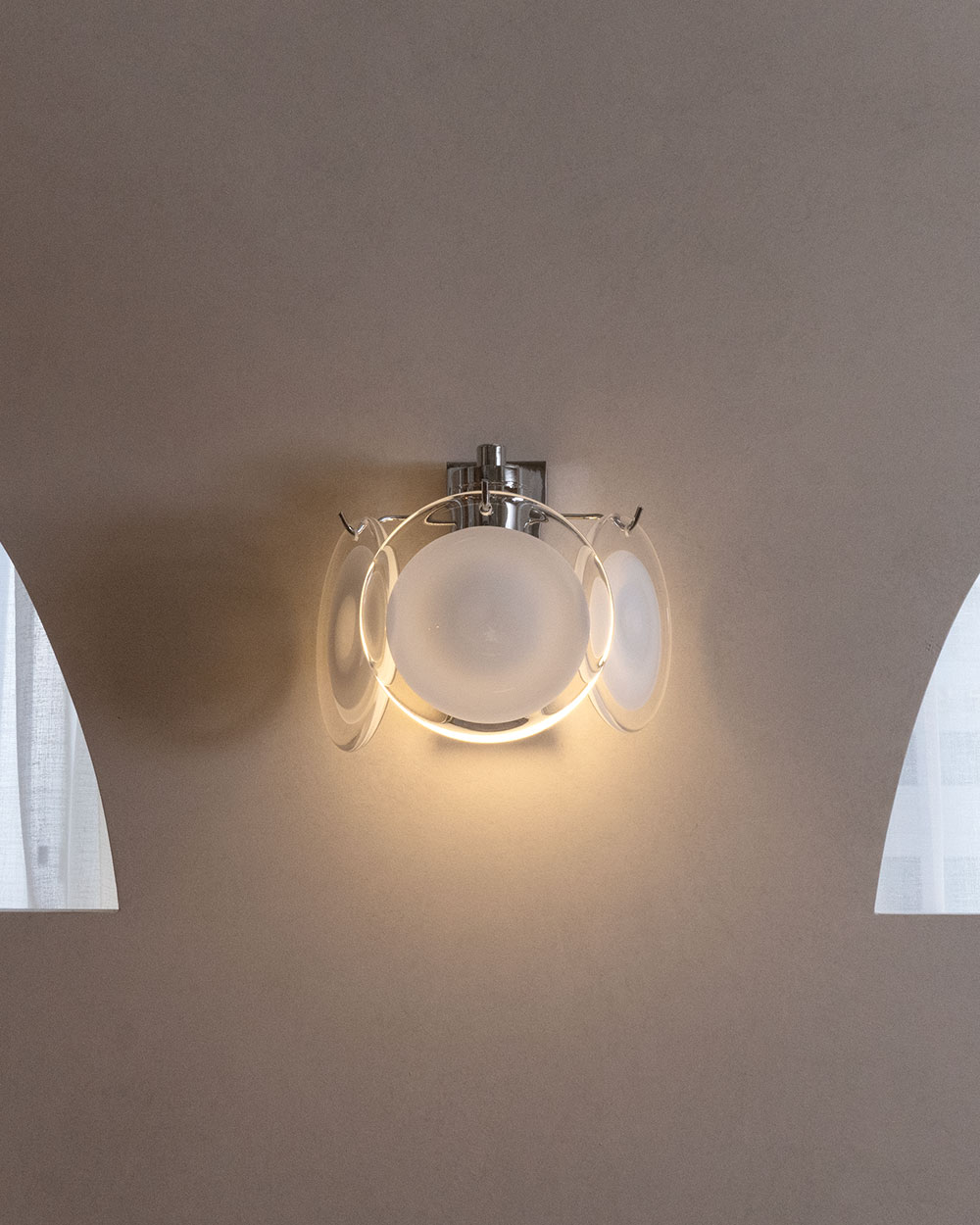 벽면에 설치된 투명 디스크형 벽등으로 간접 조명이 은은하게 퍼지며 모던한 인테리어를 완성하는 벽부등입니다.