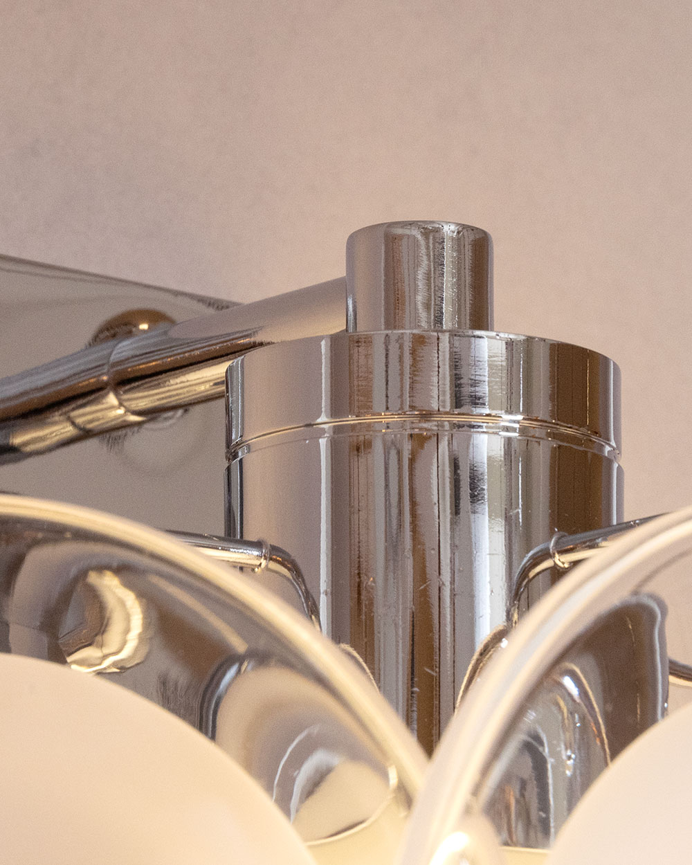 벽등 연결부 클로즈업으로 크롬 마감 처리된 메탈 베이스의 정교한 디자인과 고급스러운 품질이 돋보이는 벽조명 디테일입니다.